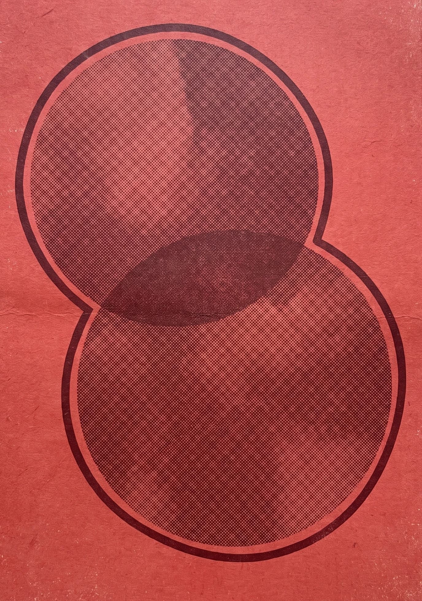 Two overlapping circles in a halftone print on red paper