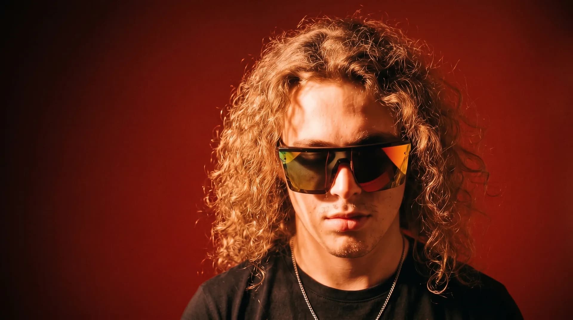 Yiğit Osman Bayrak, founder of EGORA Digital, in sunglasses against a red wall